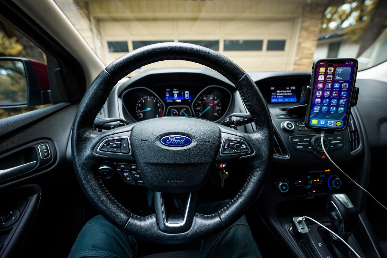Interior view of a Ford car featuring a steering wheel, dashboard, and mobile device mount.